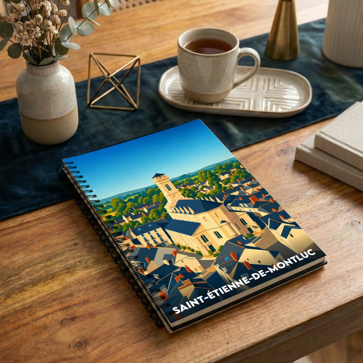 Carnet à spirales souvenir de la ville de Saint-Étienne-de-Montluc avec une illustration stylisée.