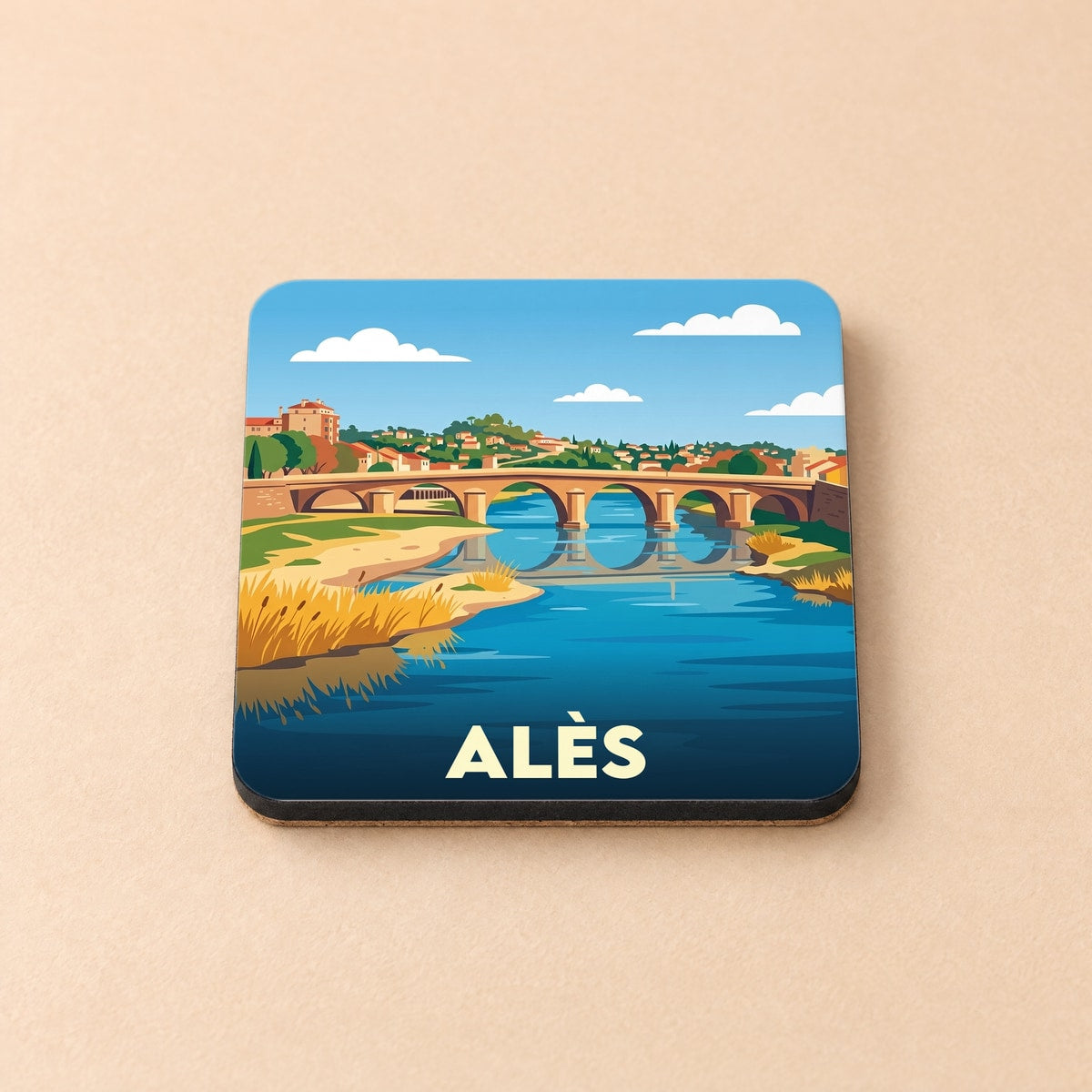 Dessous de verre souvenir de la ville d'Alès avec une illustration stylisée d'un pont enjambant une rivière.