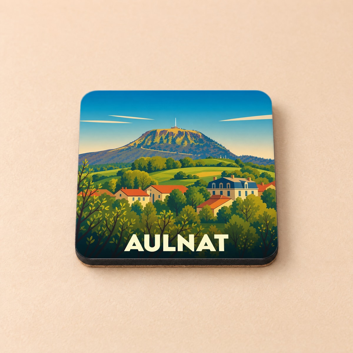 Dessous de verre souvenir de la ville d'Aulnat avec une illustration stylisée d'un paysage de montagne.