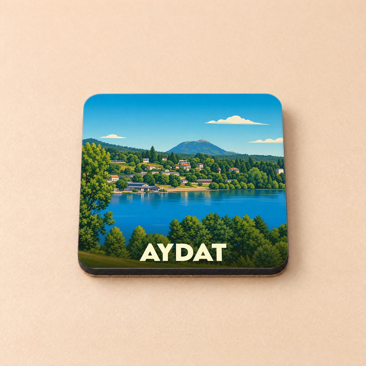 Dessous de verre souvenir de la ville d'Aydat avec une illustration stylisée de son lac et des montagnes environnantes.