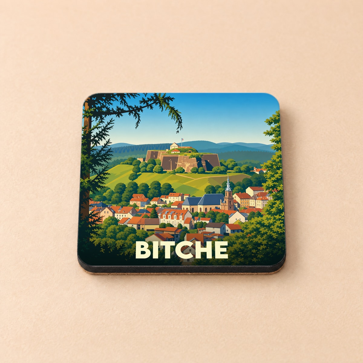Dessous de verre souvenir de la ville de Bitche avec une illustration stylisée de sa citadelle et de ses maisons colorées.