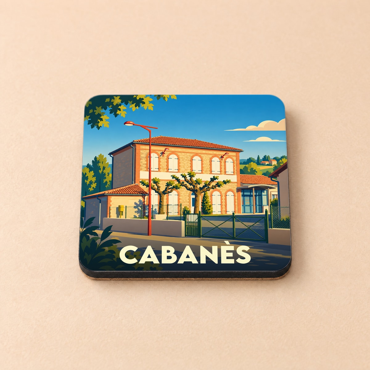 Dessous de verre souvenir de la ville de Cabanès avec une illustration stylisée d'un bâtiment traditionnel.