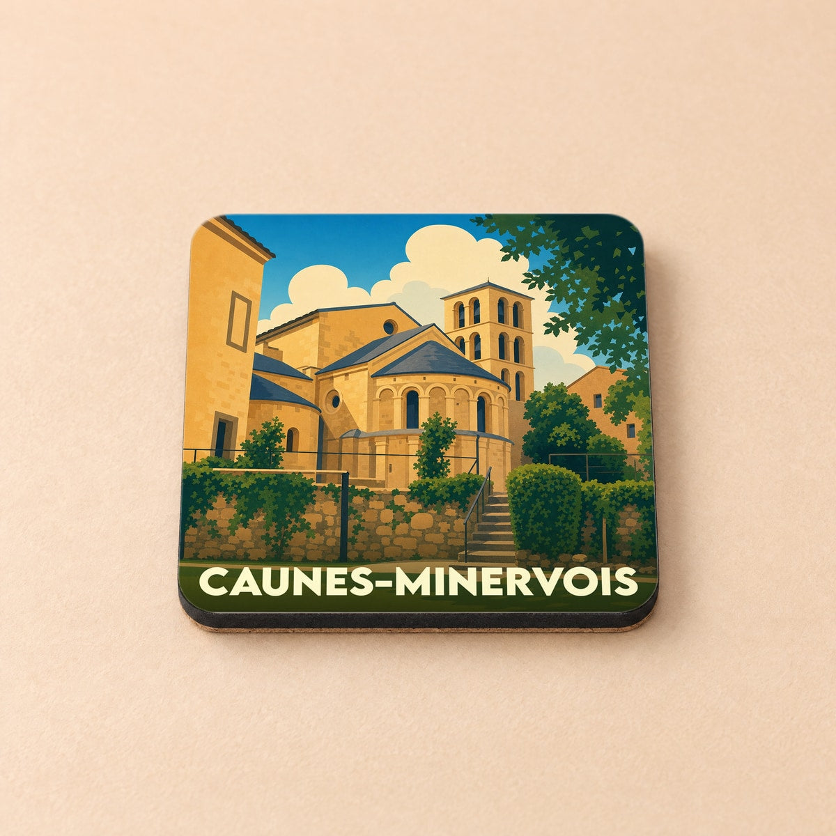 Dessous de verre souvenir de la ville de Caunes-Minervois avec une illustration stylisée de l'abbaye.