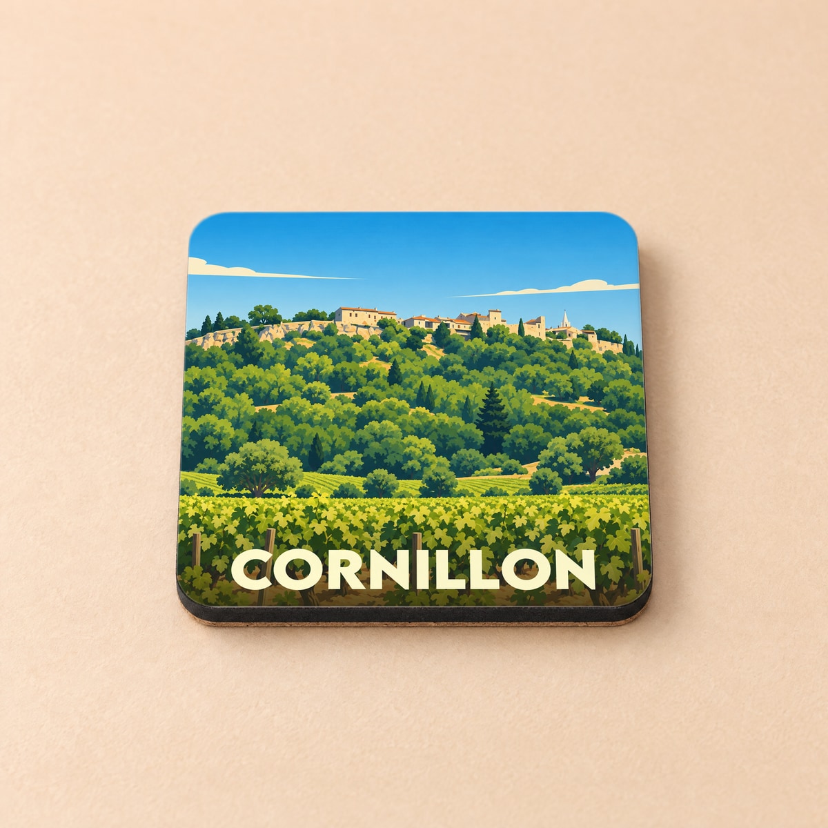 Dessous de verre souvenir de la ville de Cornillon avec une illustration stylisée d'un village perché et de vignobles.