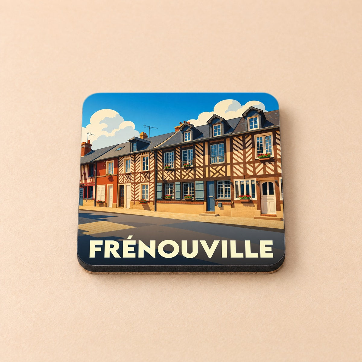 Dessous de verre souvenir de la ville de Frénouville orné d'une illustration stylisée de maisons à colombages.