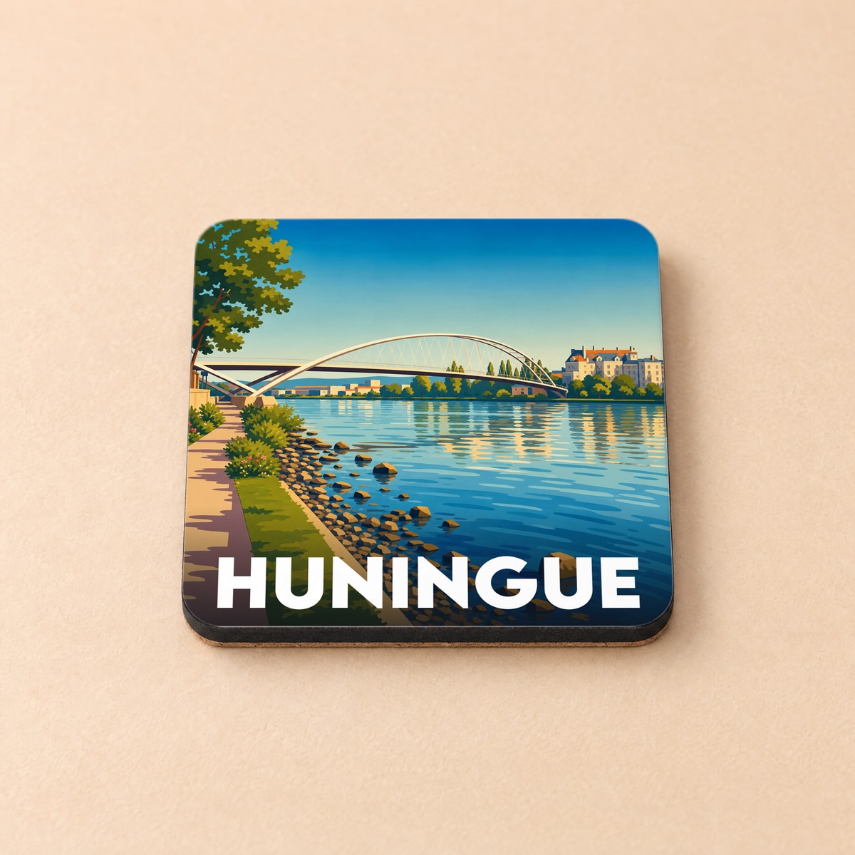 Dessous de verre souvenir de la ville de Huningue avec une illustration stylisée de la passerelle des Trois Pays enjambant le Rhin.