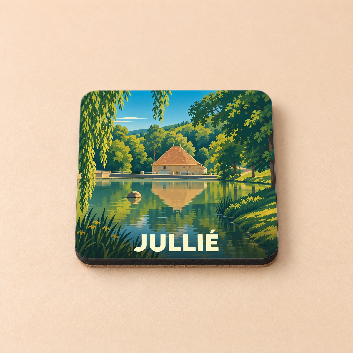 Dessous de verre souvenir de la ville de Jullié avec une illustration stylisée d'un étang et d'une maison ancienne.