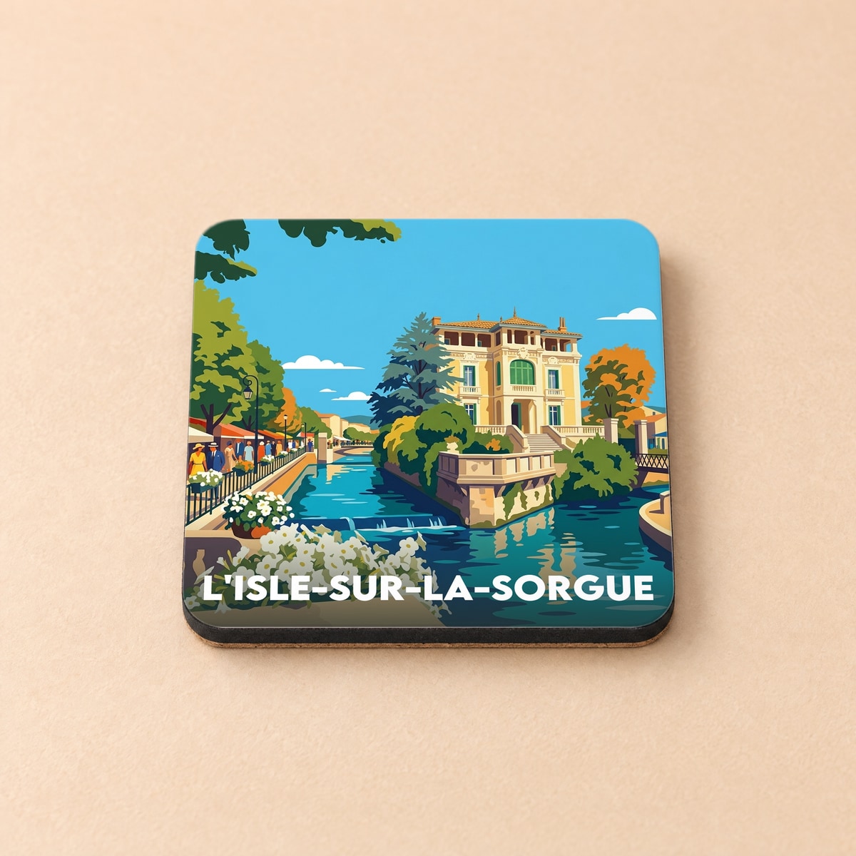 Dessous de verre souvenir de L'Isle-sur-la-Sorgue avec une illustration colorée et stylisée de la ville.
