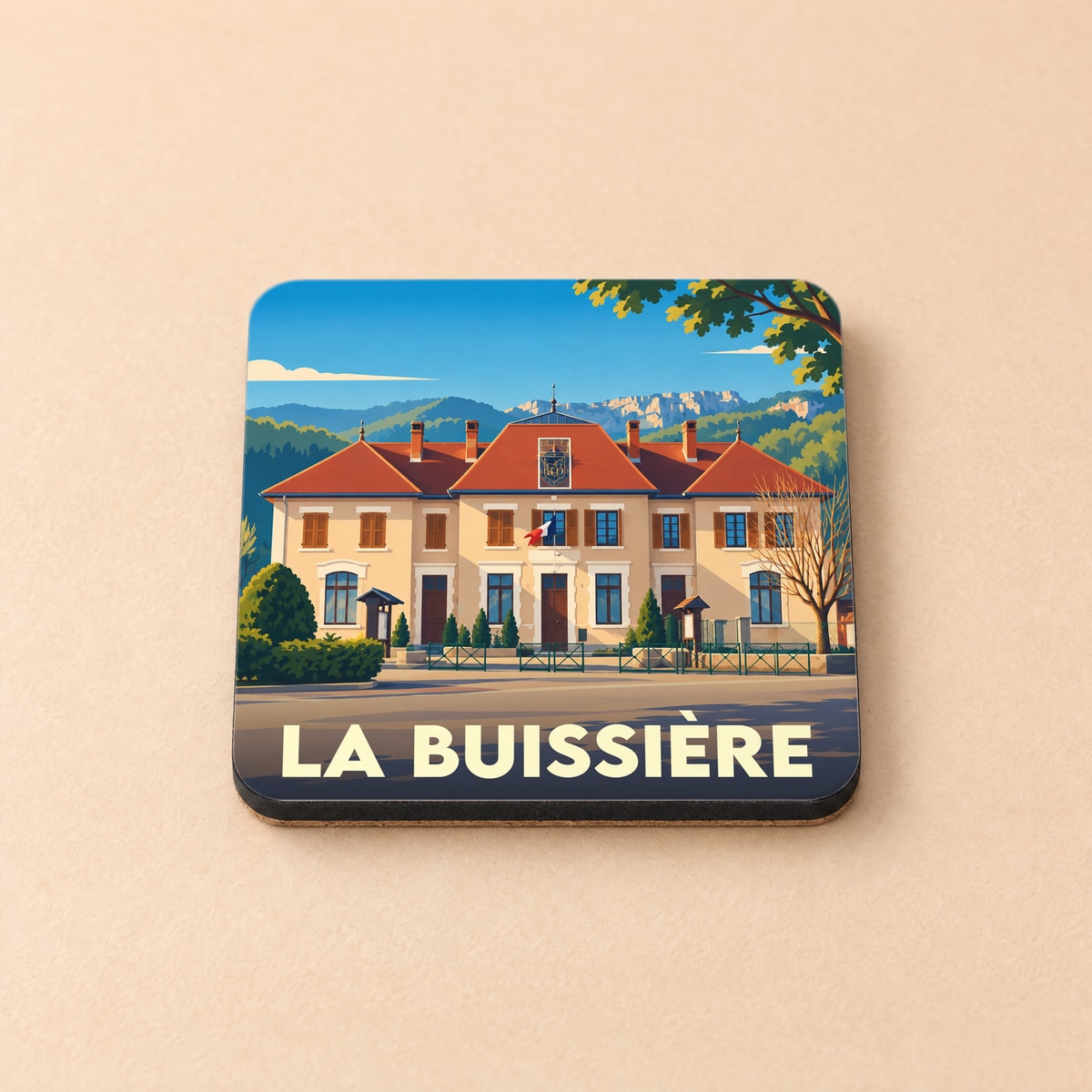 Dessous de verre souvenir de la ville de La Buissière avec une illustration stylisée de la mairie.