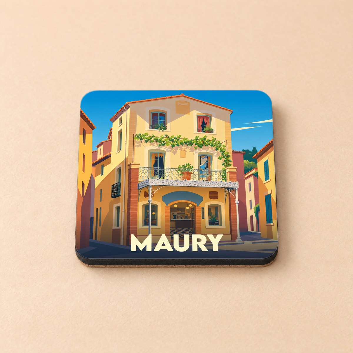 Dessous de verre souvenir de la ville de Maury avec une illustration stylisée d'une maison de village colorée.
