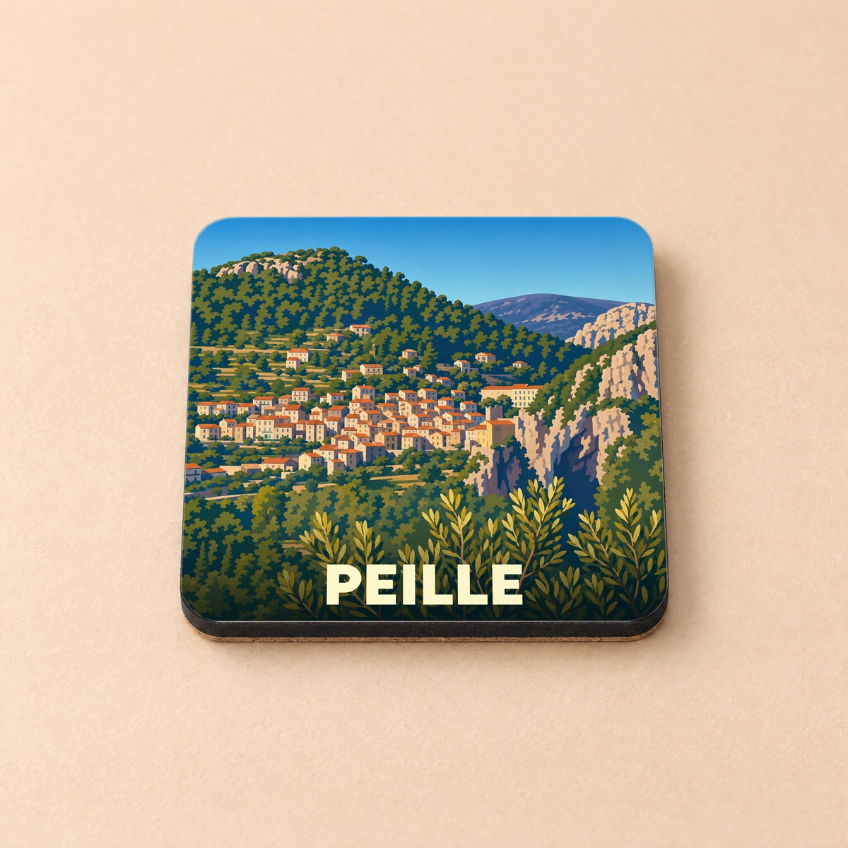 Dessous de verre souvenir de la ville de Peille avec une illustration stylisée d'un village perché.