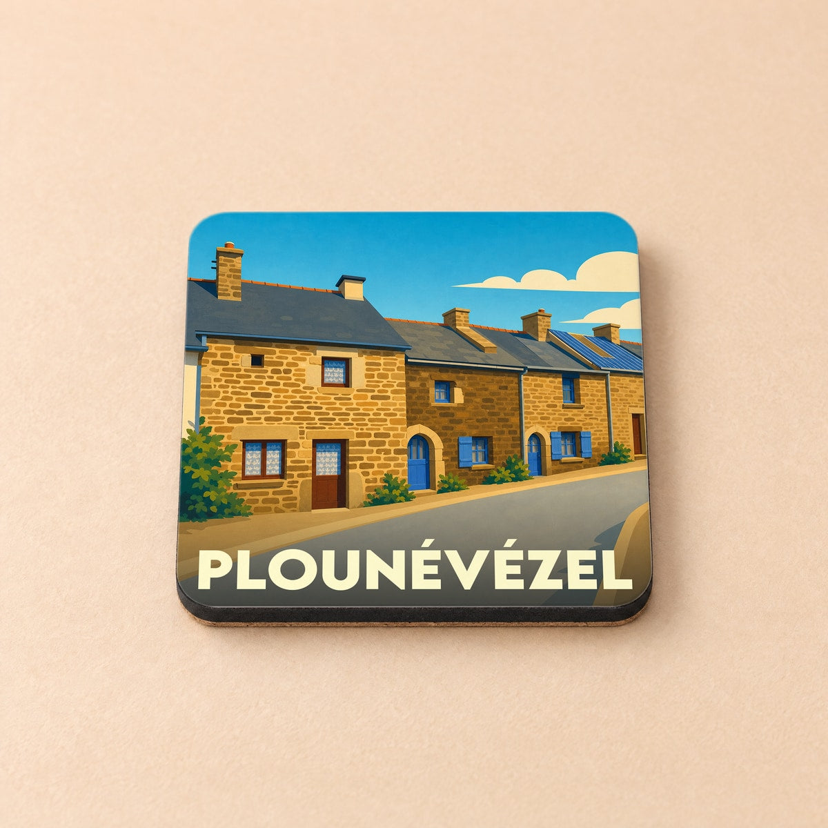 Dessous de verre souvenir de la ville de Plounévézel avec une illustration stylisée de maisons bretonnes en pierre.