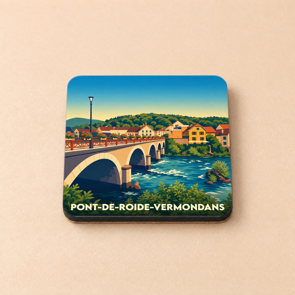 Dessous de verre souvenir de la ville de Pont-de-Roide-Vermondans avec une illustration stylisée de son pont et de ses maisons au bord de l'eau.