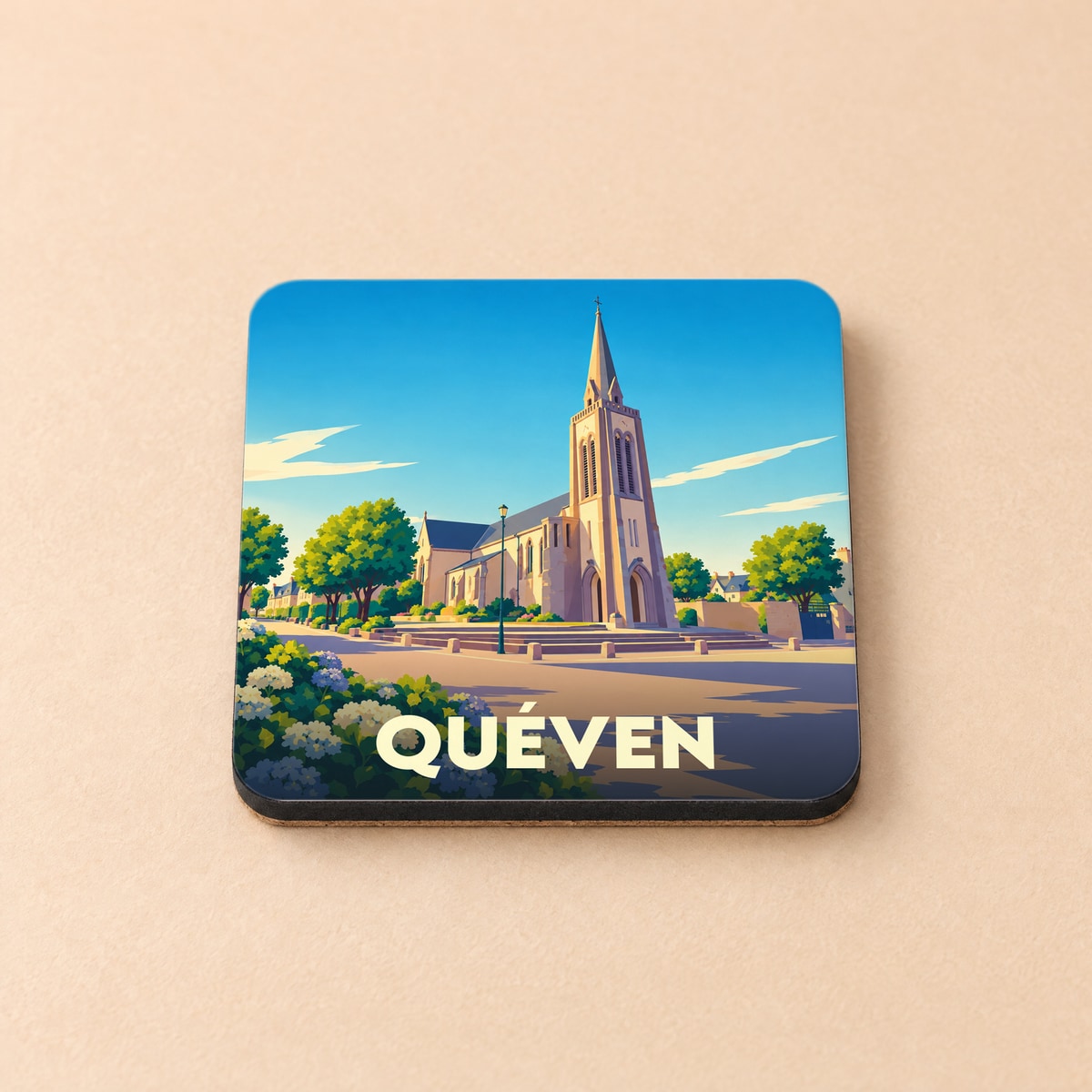 Dessous de verre souvenir de la ville de Quéven avec une illustration stylisée de son église sous un ciel bleu.