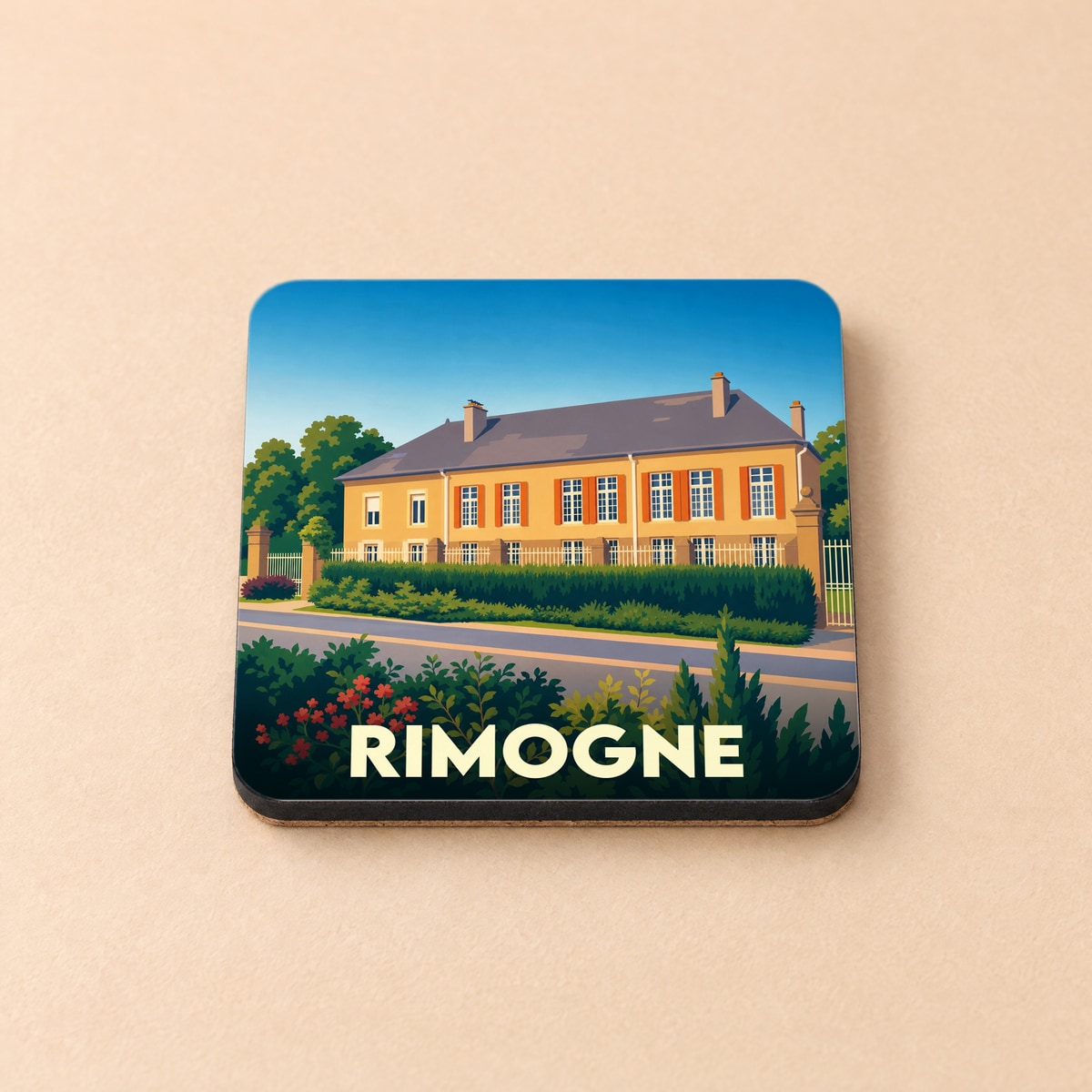 Dessous de verre souvenir de la ville de Rimogne avec une illustration stylisée d'une grande demeure.