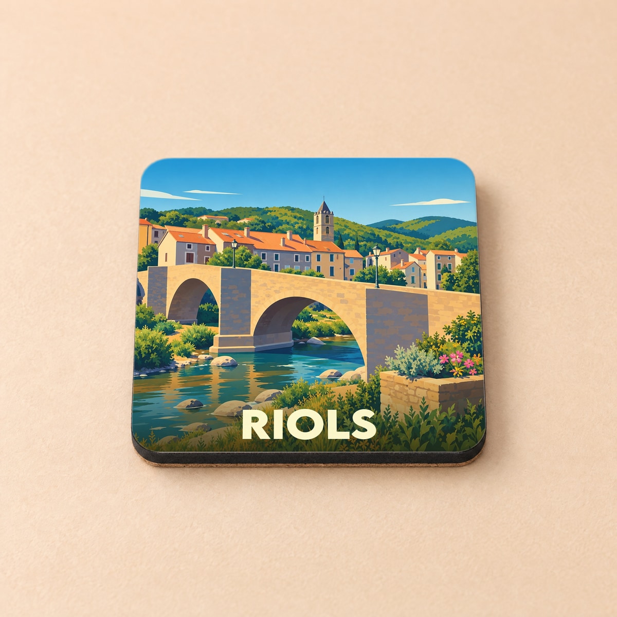 Dessous de verre souvenir de la ville de Riols avec une illustration stylisée d'un pont en pierre.