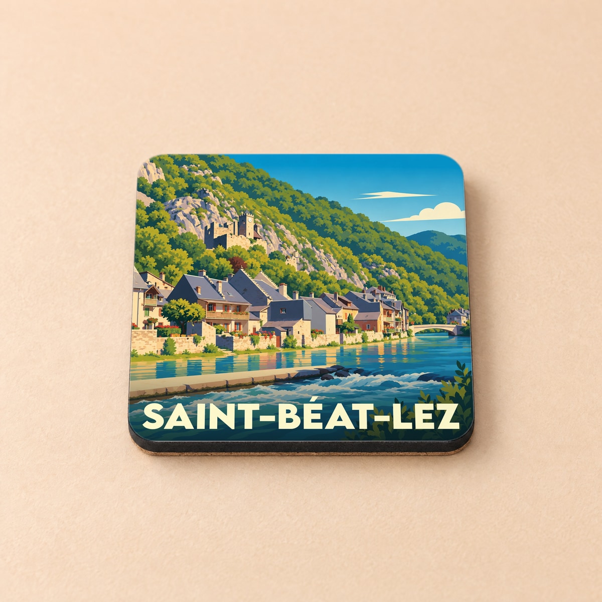 Dessous de verre souvenir de la ville de Saint-Béat-Lez avec une illustration stylisée d'un village de montagne au bord de l'eau.