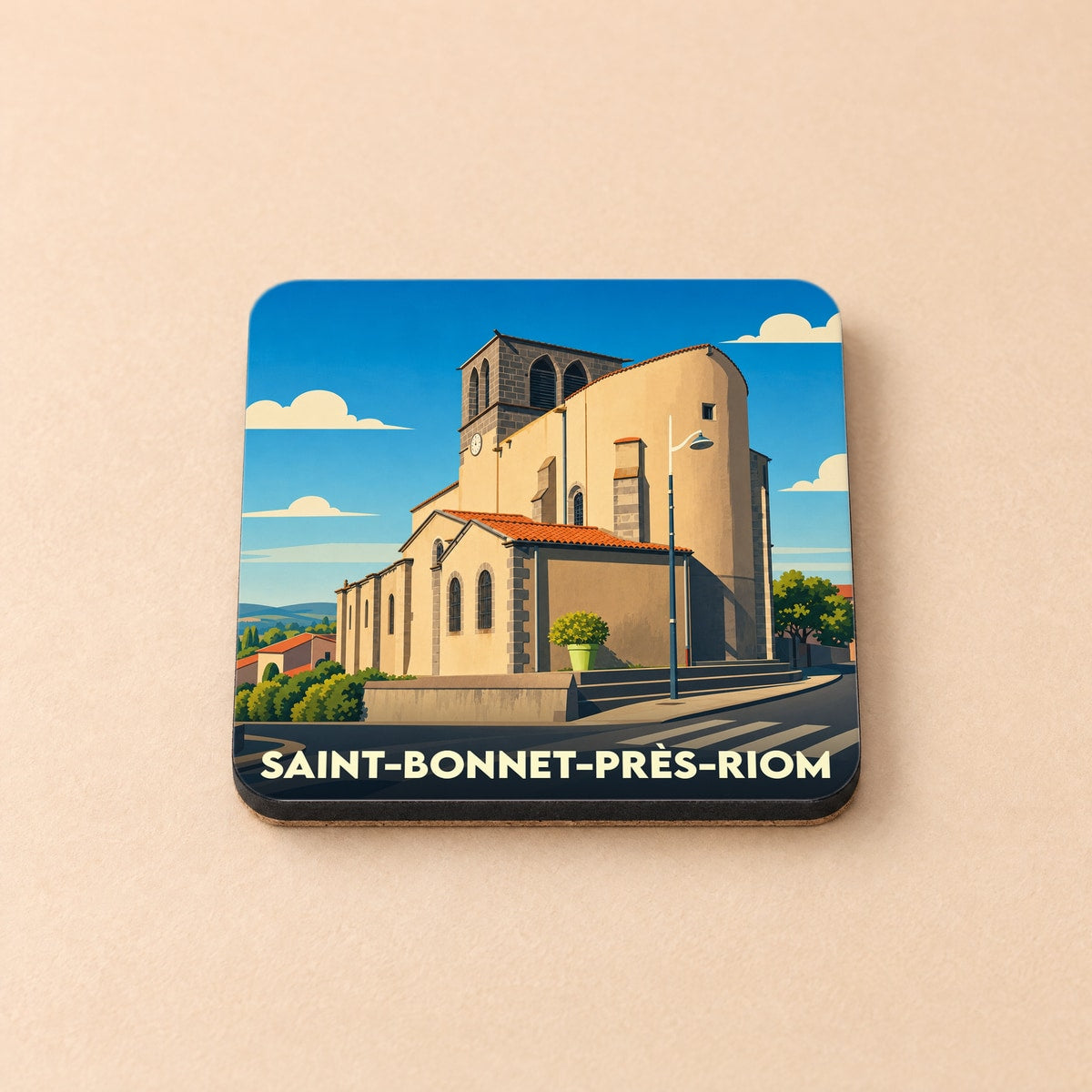 Dessous de verre souvenir de la ville de Saint-Bonnet-près-Riom avec une illustration stylisée de son église.