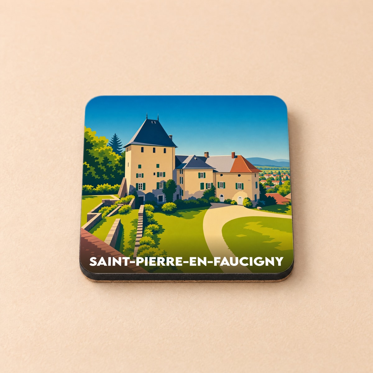 Dessous de verre souvenir de la ville de Saint-Pierre-en-Faucigny illustré d'un château stylisé.