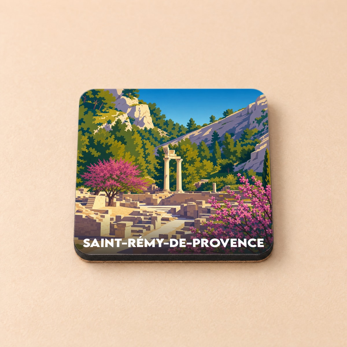 Dessous de verre souvenir de Saint-Rémy-de-Provence illustrant des ruines antiques nichées dans un paysage vallonné.