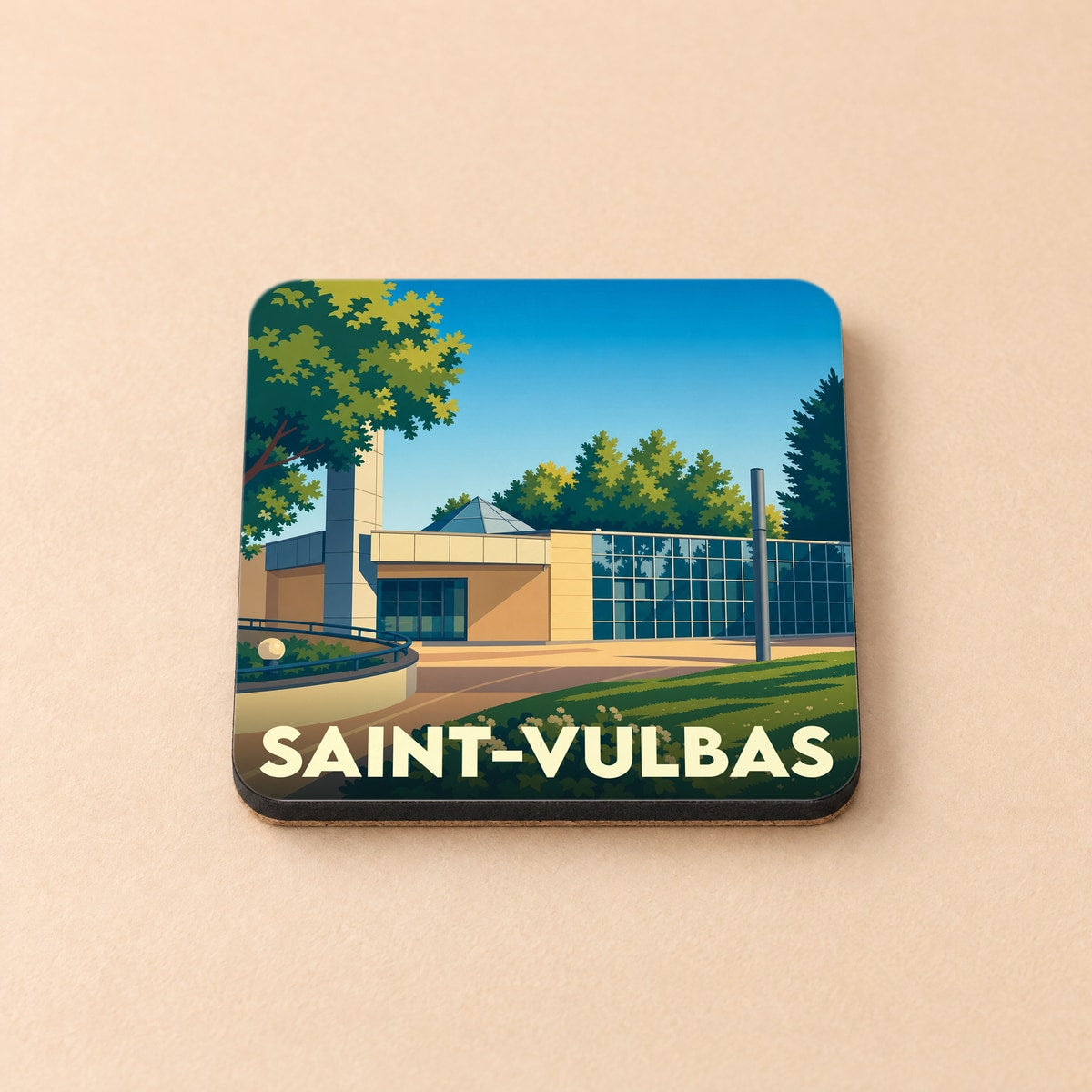 Dessous de verre souvenir de la ville de Saint-Vulbas avec une illustration stylisée d'un bâtiment moderne et arboré.