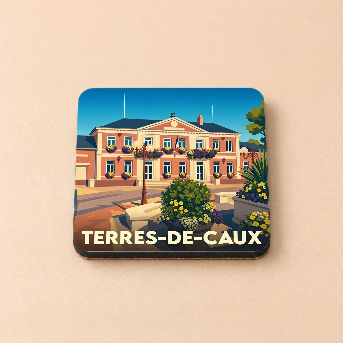 Dessous de verre souvenir de la ville de Terres-de-Caux avec une illustration stylisée de son hôtel de ville fleuri.