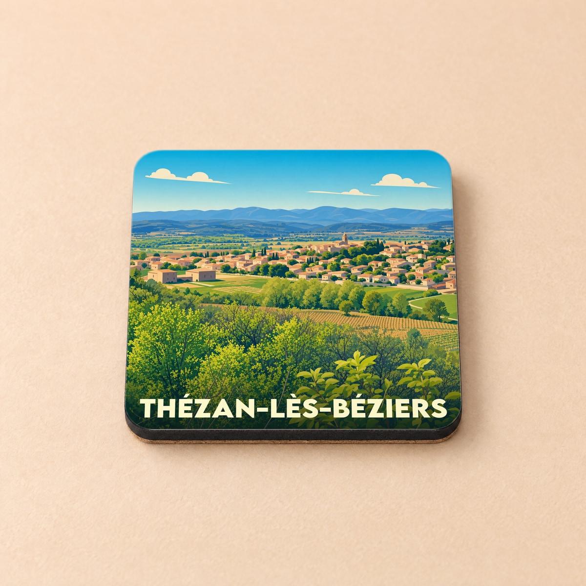 Dessous de verre souvenir de la ville de Thézan-lès-Béziers avec une illustration stylisée de son paysage.