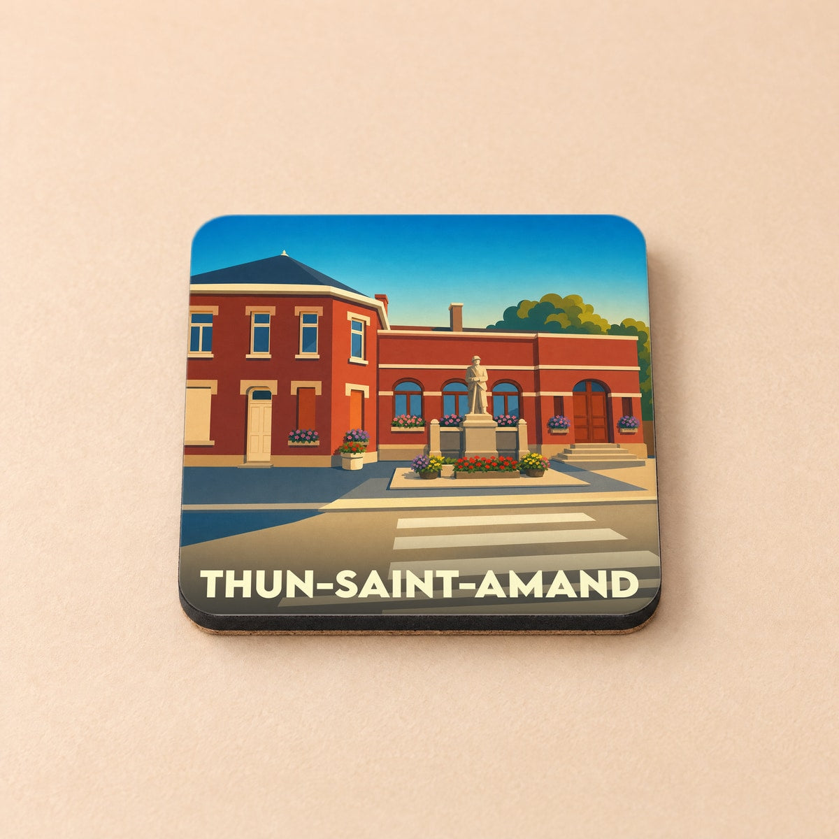 Dessous de verre souvenir de la ville de Thun-Saint-Amand avec une illustration stylisée d'une place bordée de bâtiments en briques.