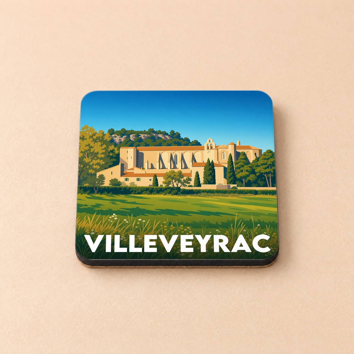 Dessous de verre souvenir de la ville de Villeveyrac avec une illustration stylisée de son abbaye.