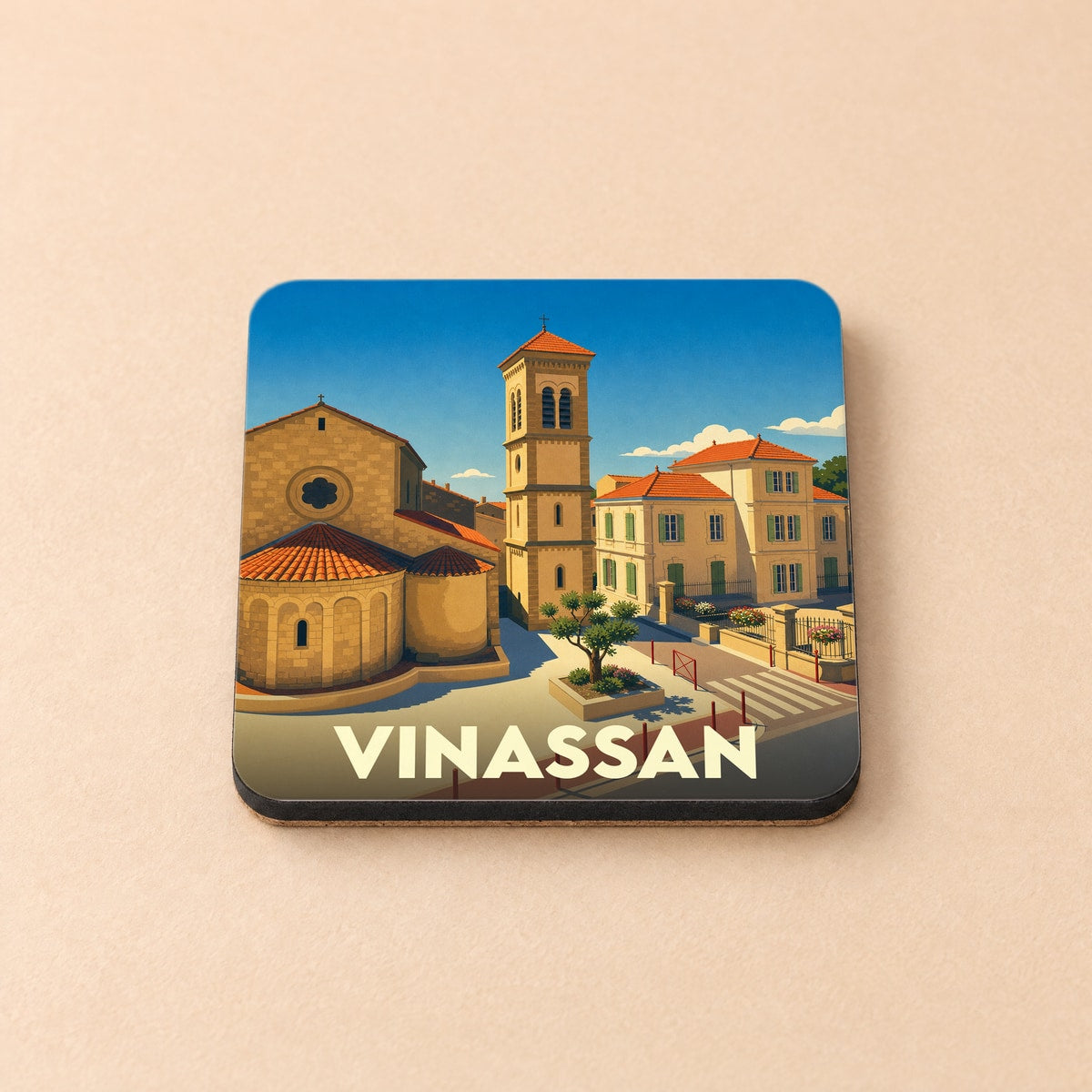Dessous de verre souvenir de la ville de Vinassan avec une illustration stylisée de son église et de ses bâtiments ensoleillés.