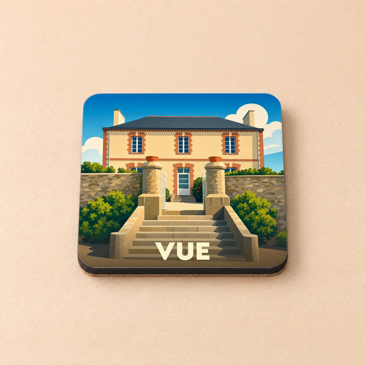 Dessous de verre souvenir de la ville de Vue avec une illustration stylisée d'une maison de maître.