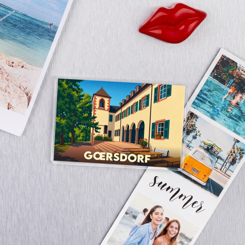 Magnet souvenir de la ville de Gœrsdorf avec une illustration stylisée d'un bâtiment historique.