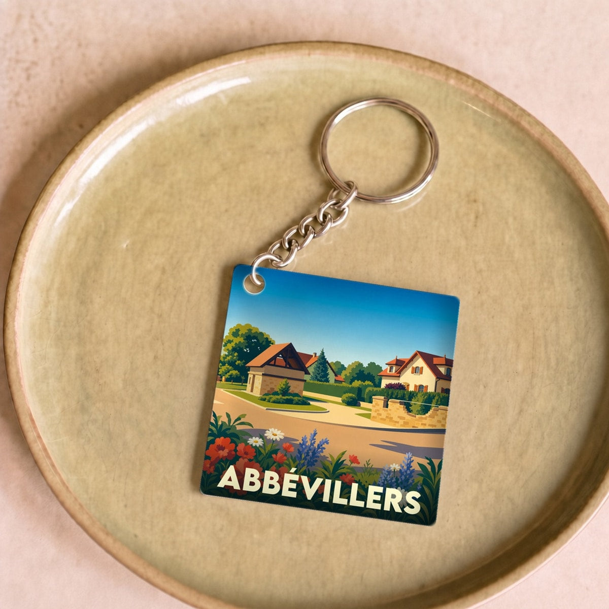Porte-clés souvenir de la ville d'Abbévillers avec une illustration paysagère stylisée.