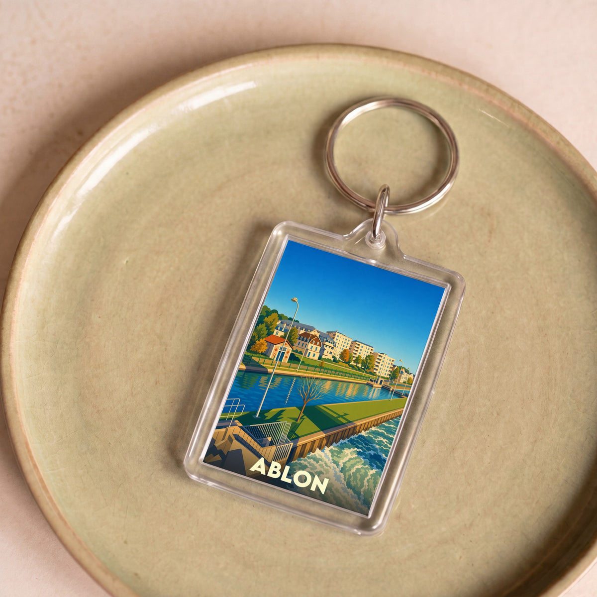 Porte-clés souvenir de la ville d'Ablon avec une illustration stylisée de son paysage fluvial.