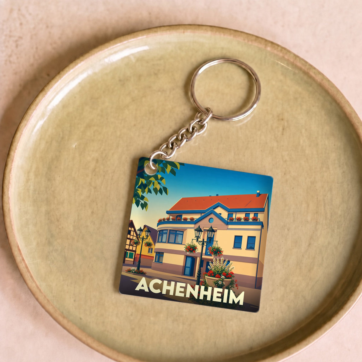 Porte-clés souvenir de la ville d'Achenheim avec une illustration stylisée de ses maisons traditionnelles.