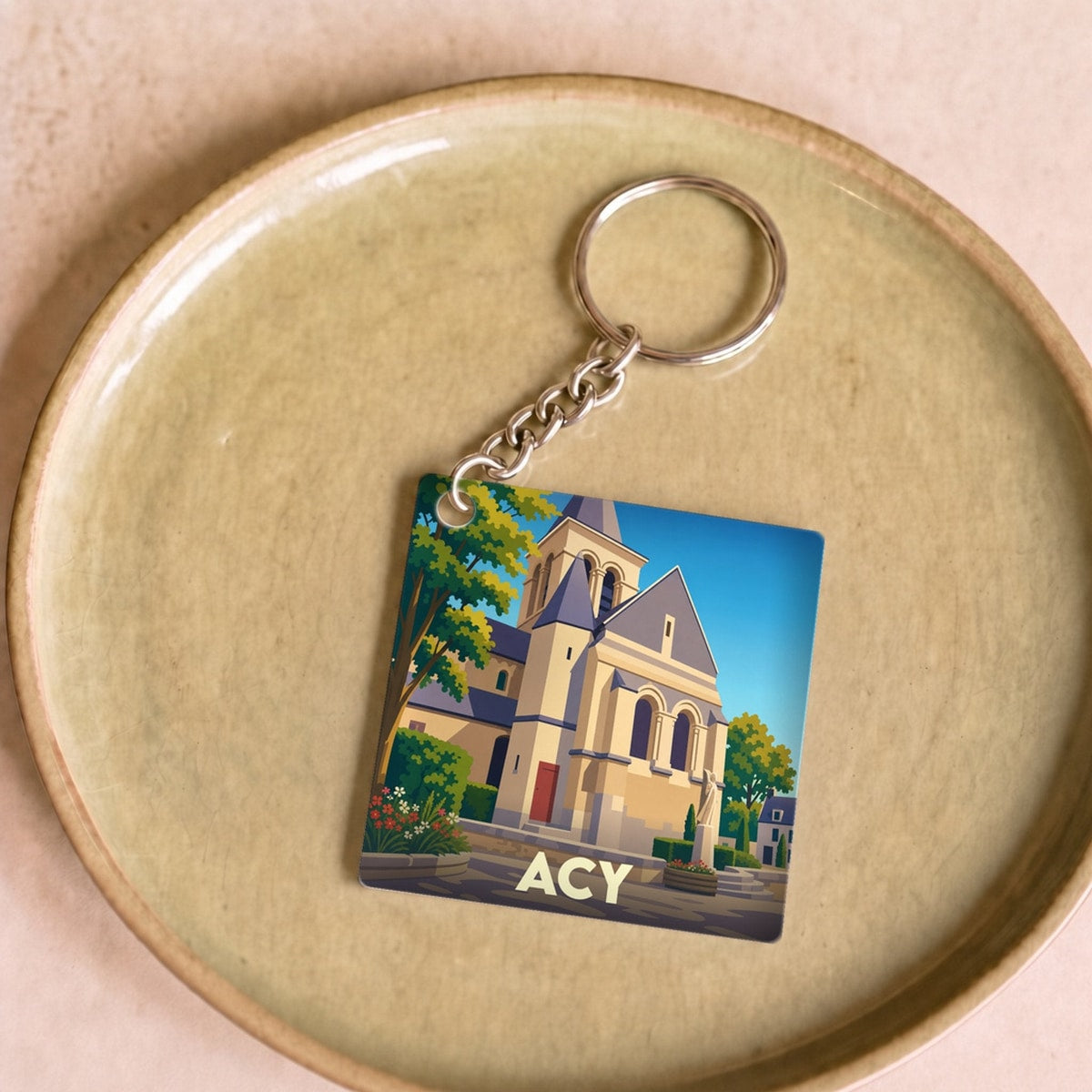 Porte-clés souvenir de la ville d'Acy avec une illustration stylisée de son église.