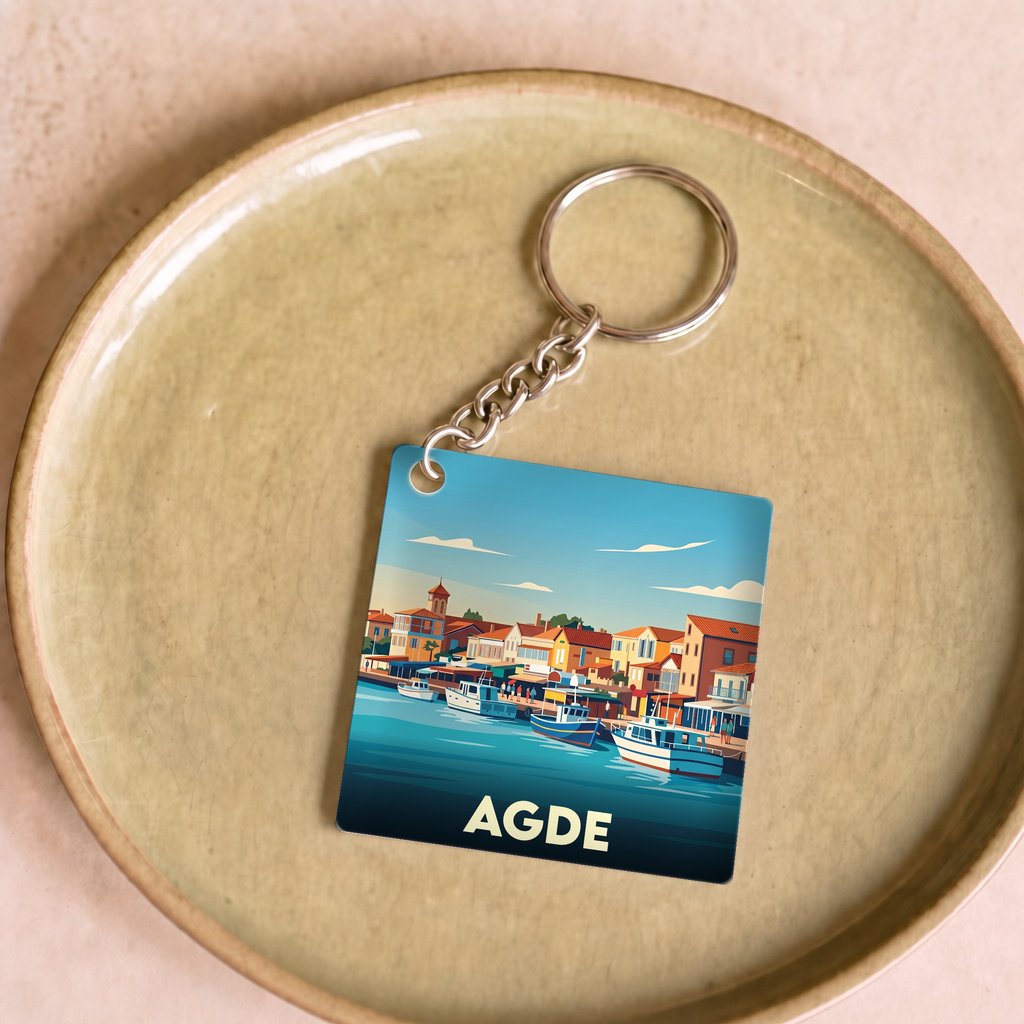 Porte-clés souvenir de la ville d'Agde avec une illustration stylisée du port.
