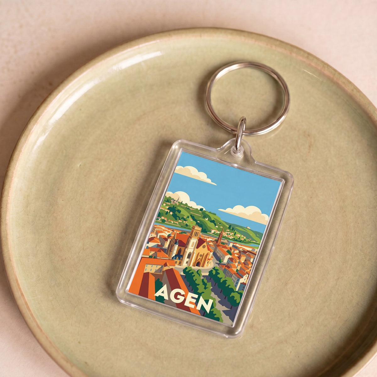 Porte-clés souvenir de la ville d'Agen avec une illustration stylisée.
