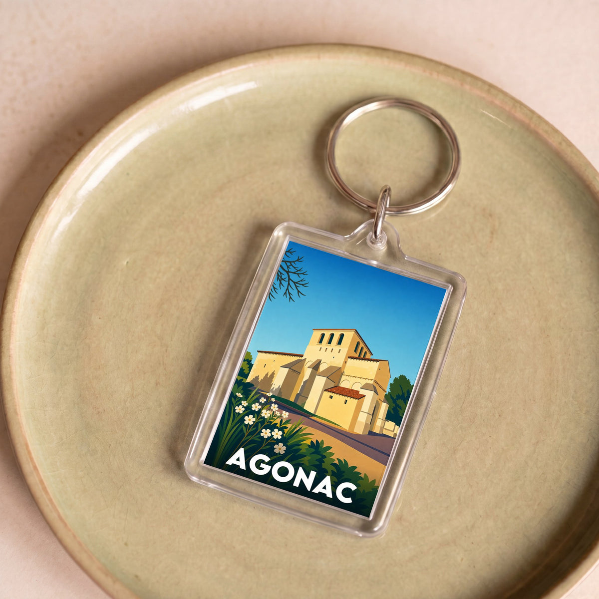 Porte-clés souvenir de la ville d'Agonac avec une illustration stylisée.