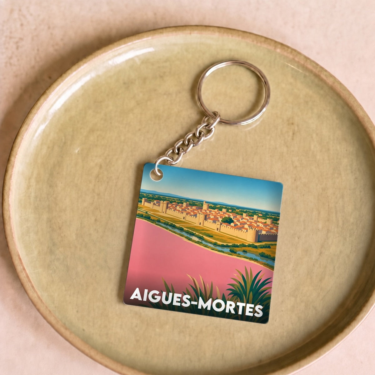 Porte-clés souvenir de la ville d'Aigues-Mortes avec une illustration stylisée.