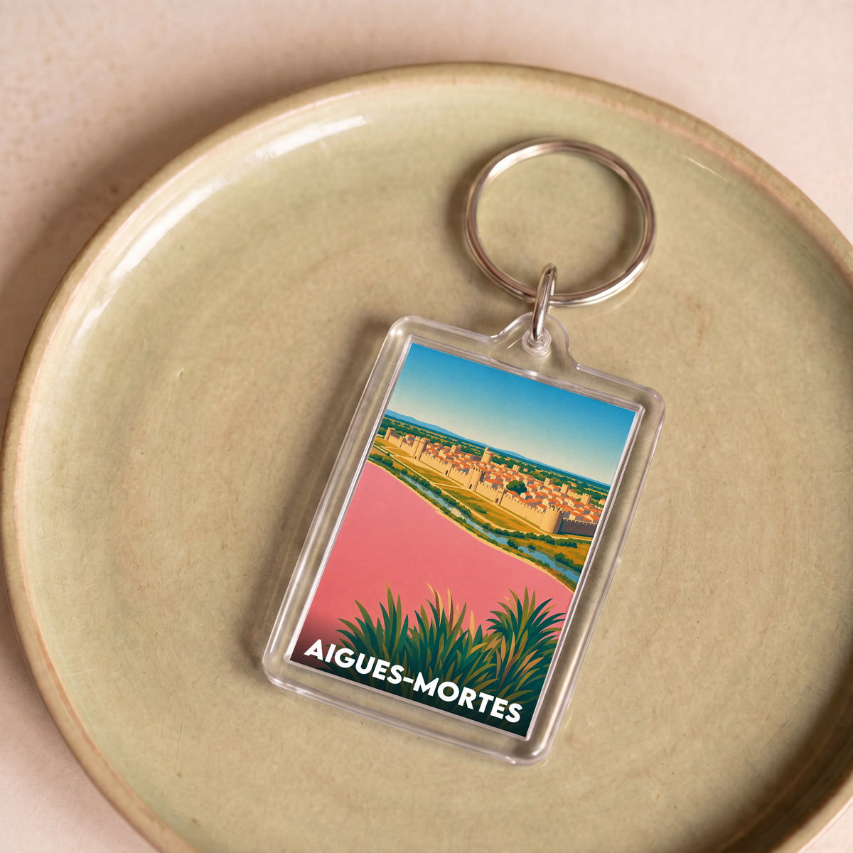 Porte-clés souvenir de la ville d'Aigues-Mortes avec une illustration stylisée.