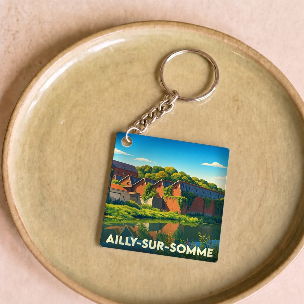 Porte-clés souvenir de la ville d'Ailly-sur-Somme avec une illustration stylisée.