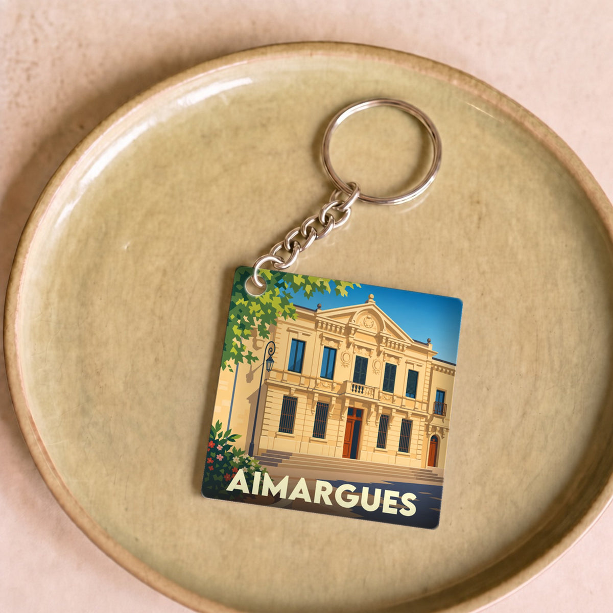Porte-clés souvenir de la ville d'Aimargues avec une illustration stylisée de son hôtel de ville.