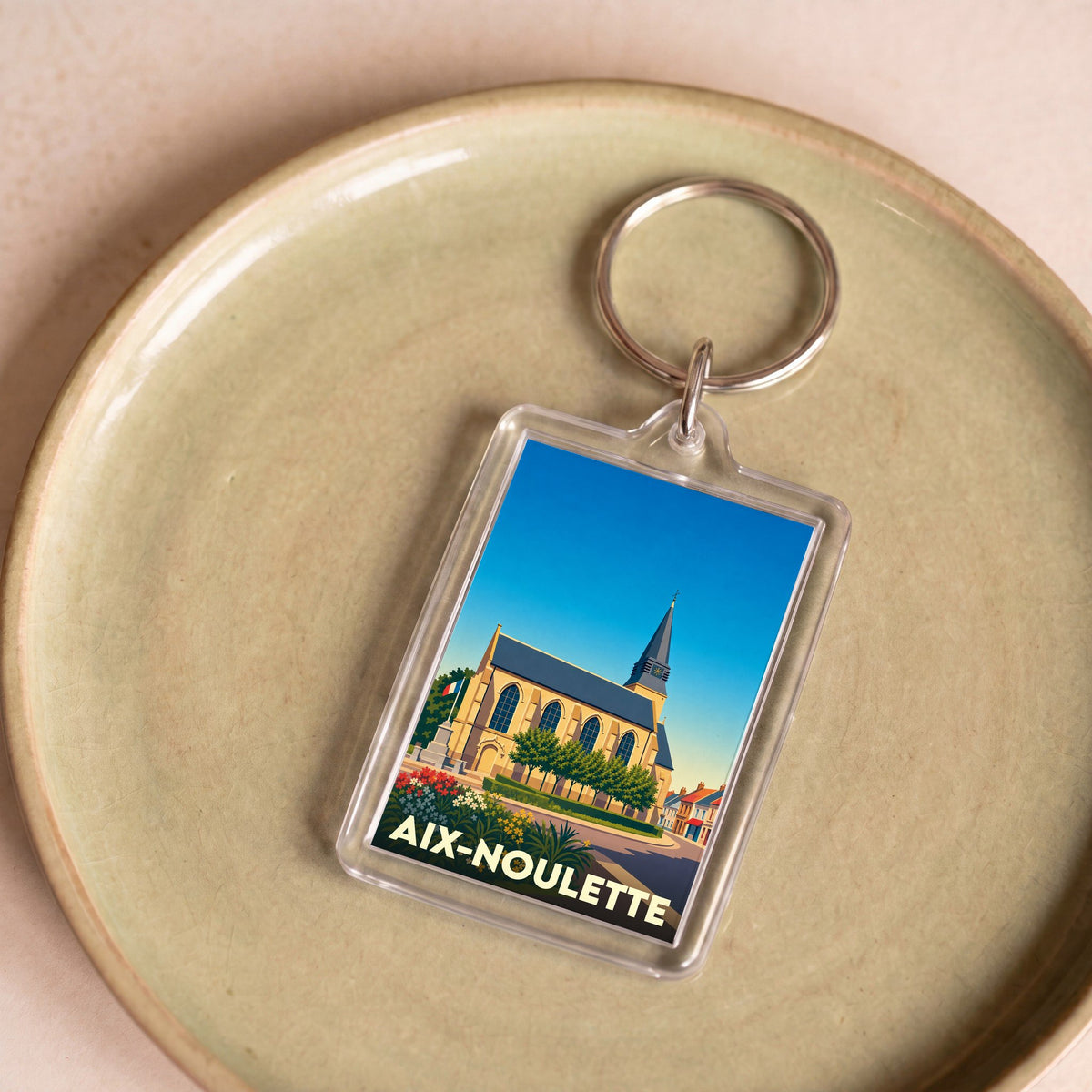 Porte-clés souvenir de la ville d'Aix-Noulette avec une illustration stylisée de son église.