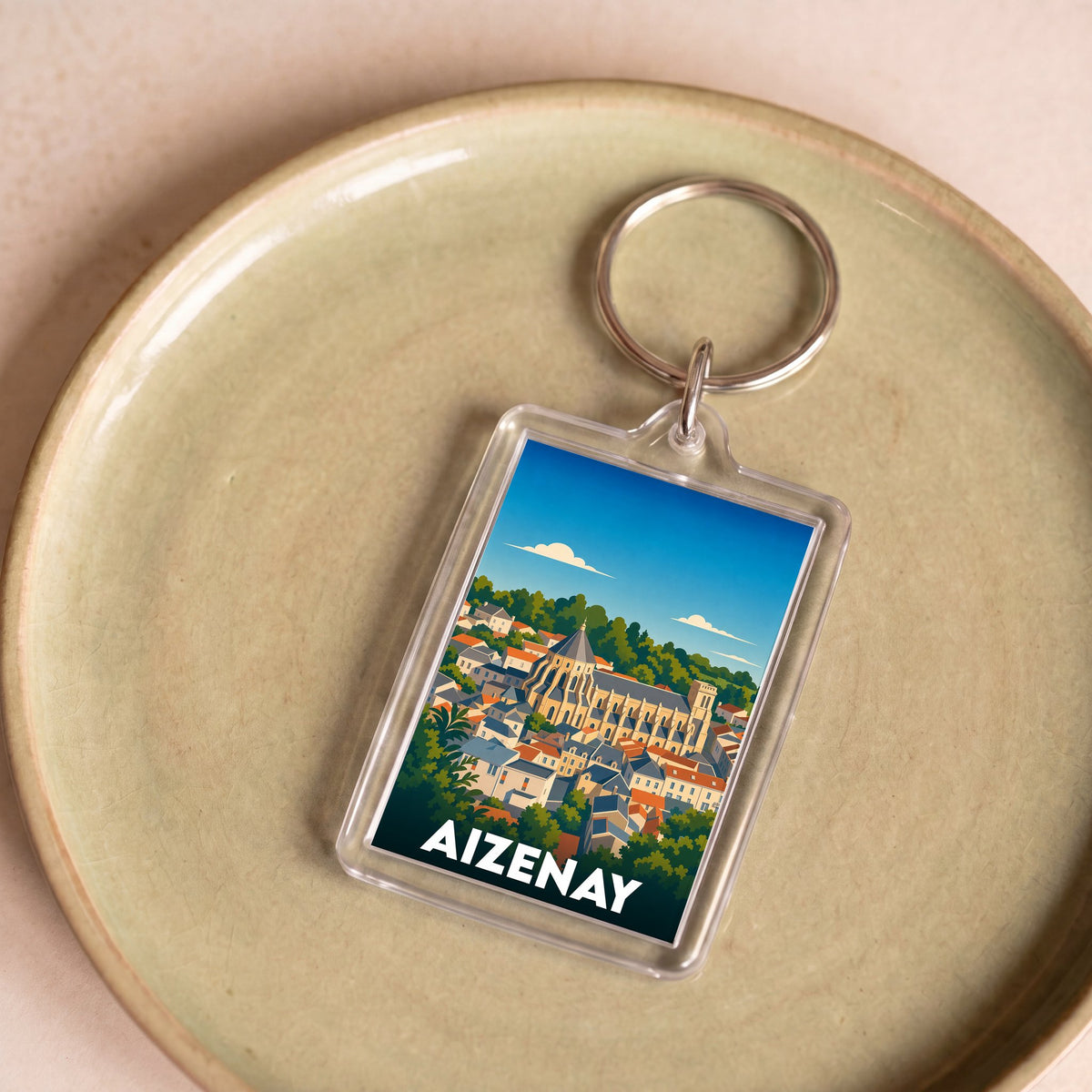 Porte-clés souvenir de la ville d'Aizenay avec une illustration stylisée.