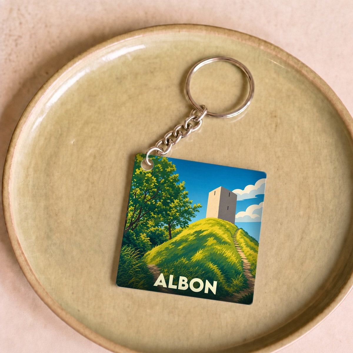 Porte-clés souvenir de la ville d'Albon avec une illustration stylisée d'une tour sur une colline.