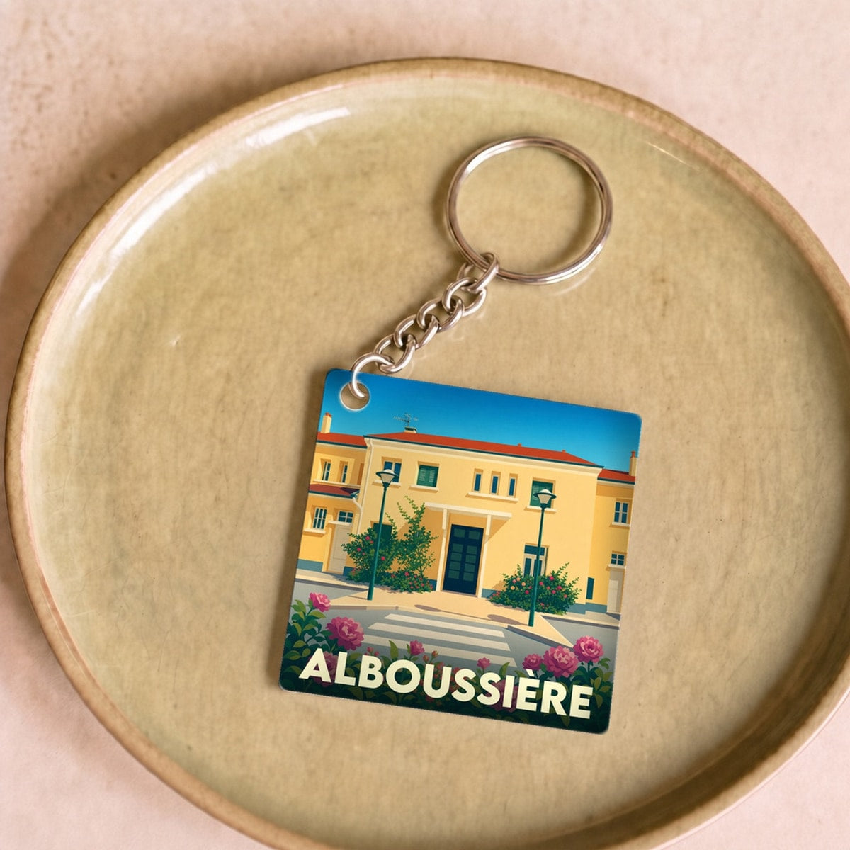 Porte-clés souvenir de la ville d'Alboussière avec une illustration stylisée.