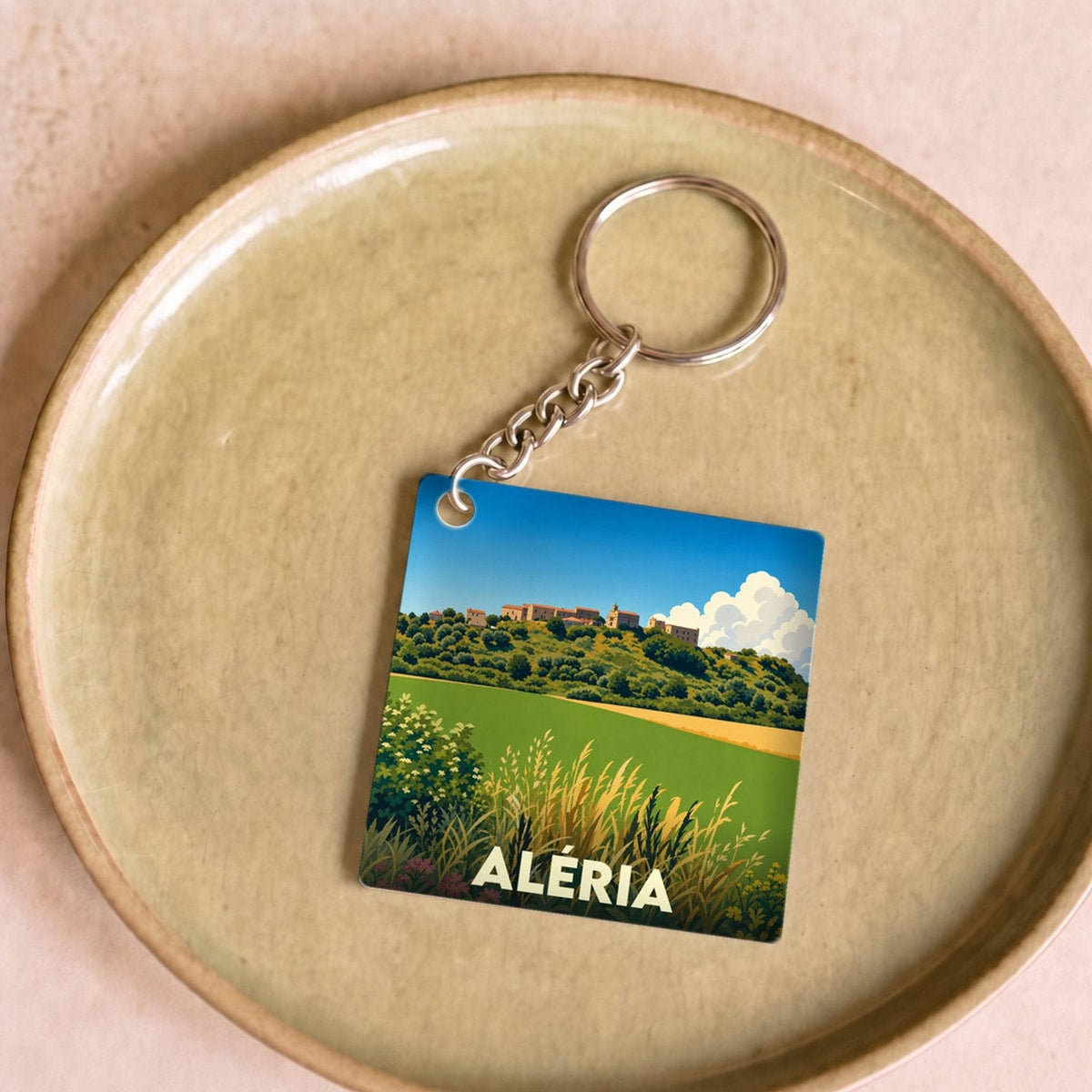 Porte-clés souvenir de la ville d'Aléria avec une illustration stylisée de son paysage.