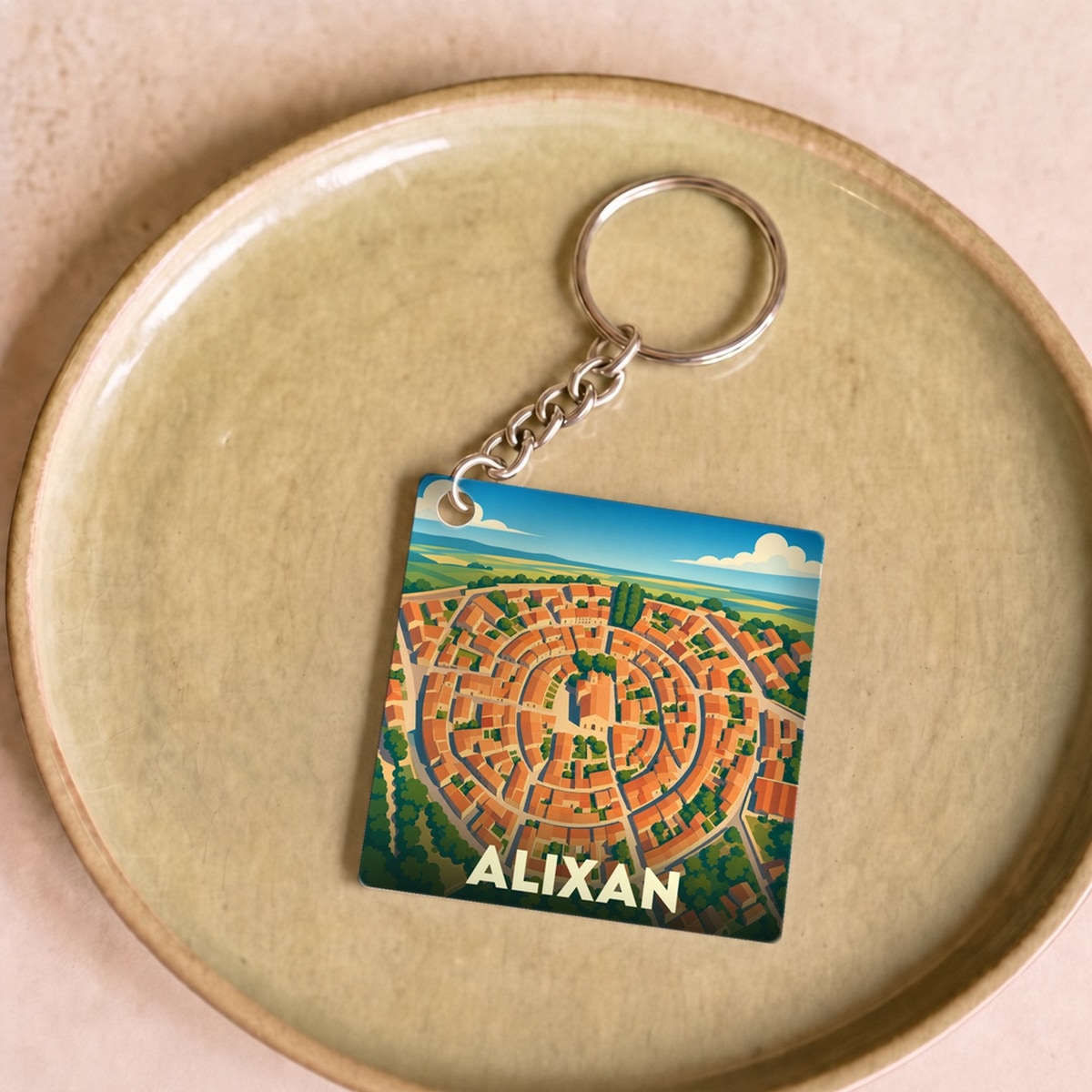 Porte-clés souvenir de la ville d'Alixan avec une illustration stylisée de son village circulaire.
