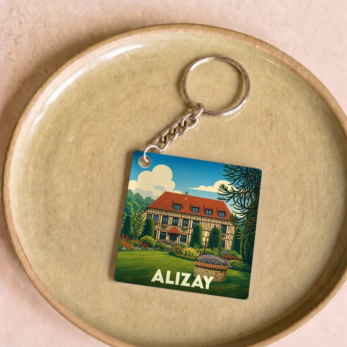 Porte-clés souvenir de la ville d'Alizay avec une illustration stylisée.